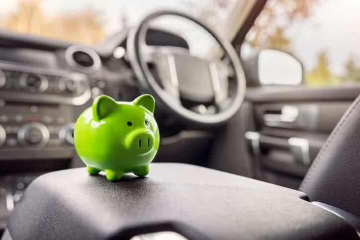 Green piggy bank money box inside car