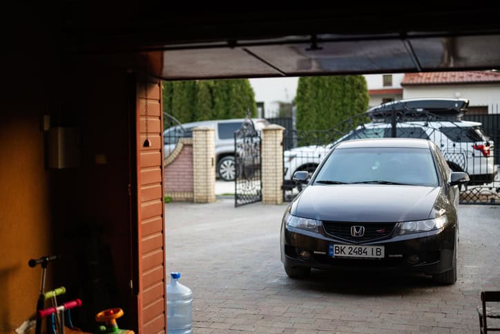 A honda accord parked in a driveway outside of a garage