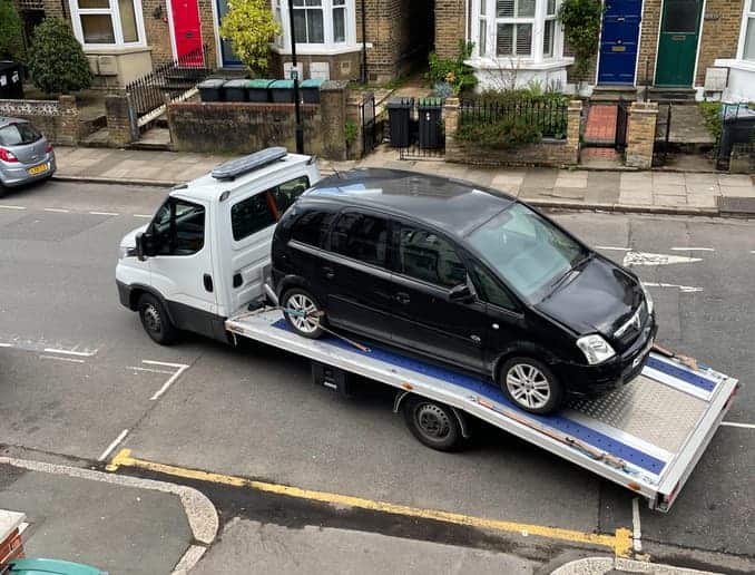 A vehicle recovery truck carrying away a broken down car