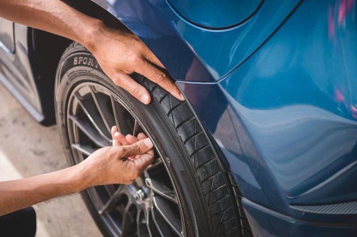 Closeup male automotive technician removing tire valve nitrogen cap for tire inflation service at garage
