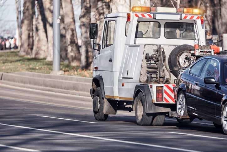 Tow truck carrying improperly parked car or repossesed vehicle